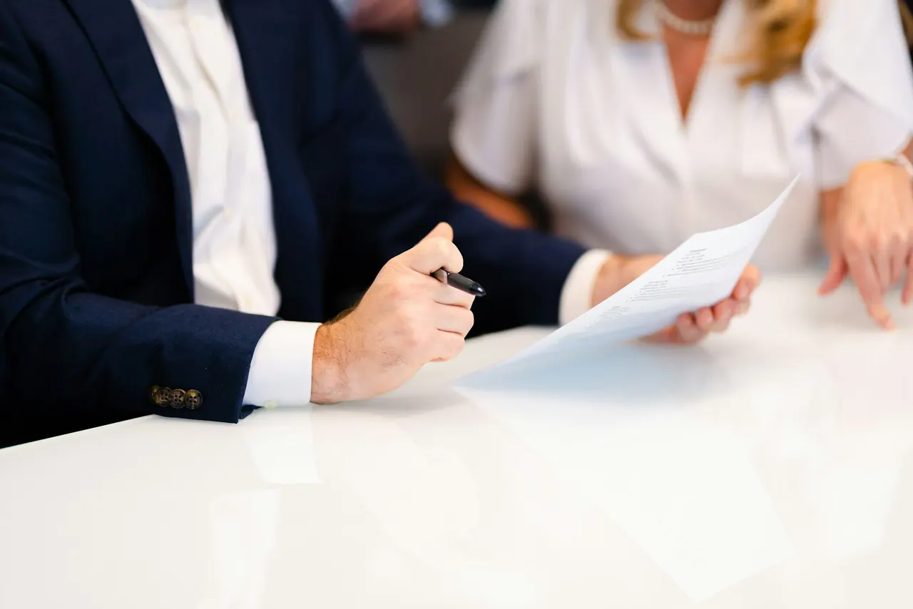 مستشار وعميل يراجعان أوراقًا على طاولة بيضاء