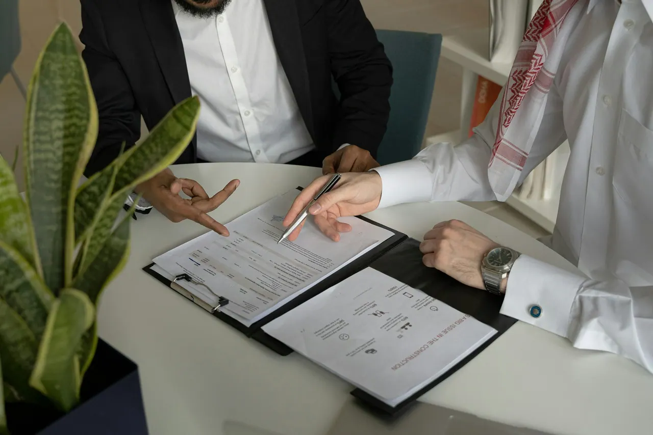 مستشاران يراجعان ملفًا بالقلم على طاولة