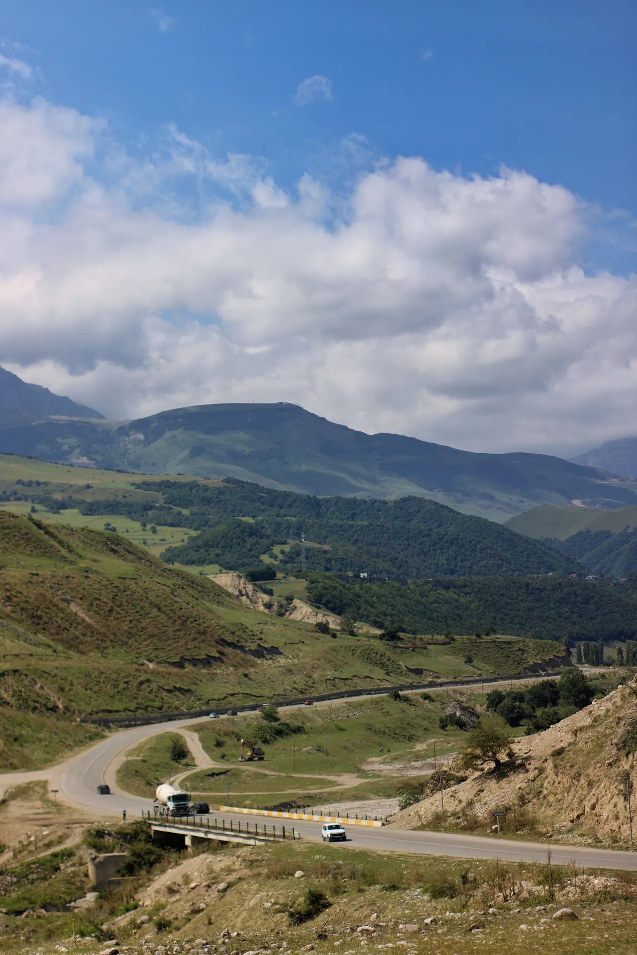 Qusarda yaşıl dağlar arasından keçən yol